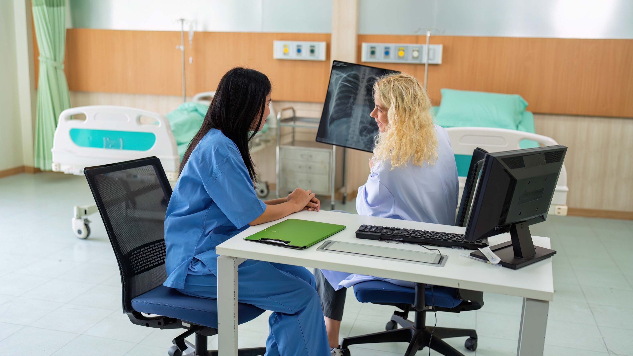 Two radiology residents looking at an x-ray on a computer monitor.