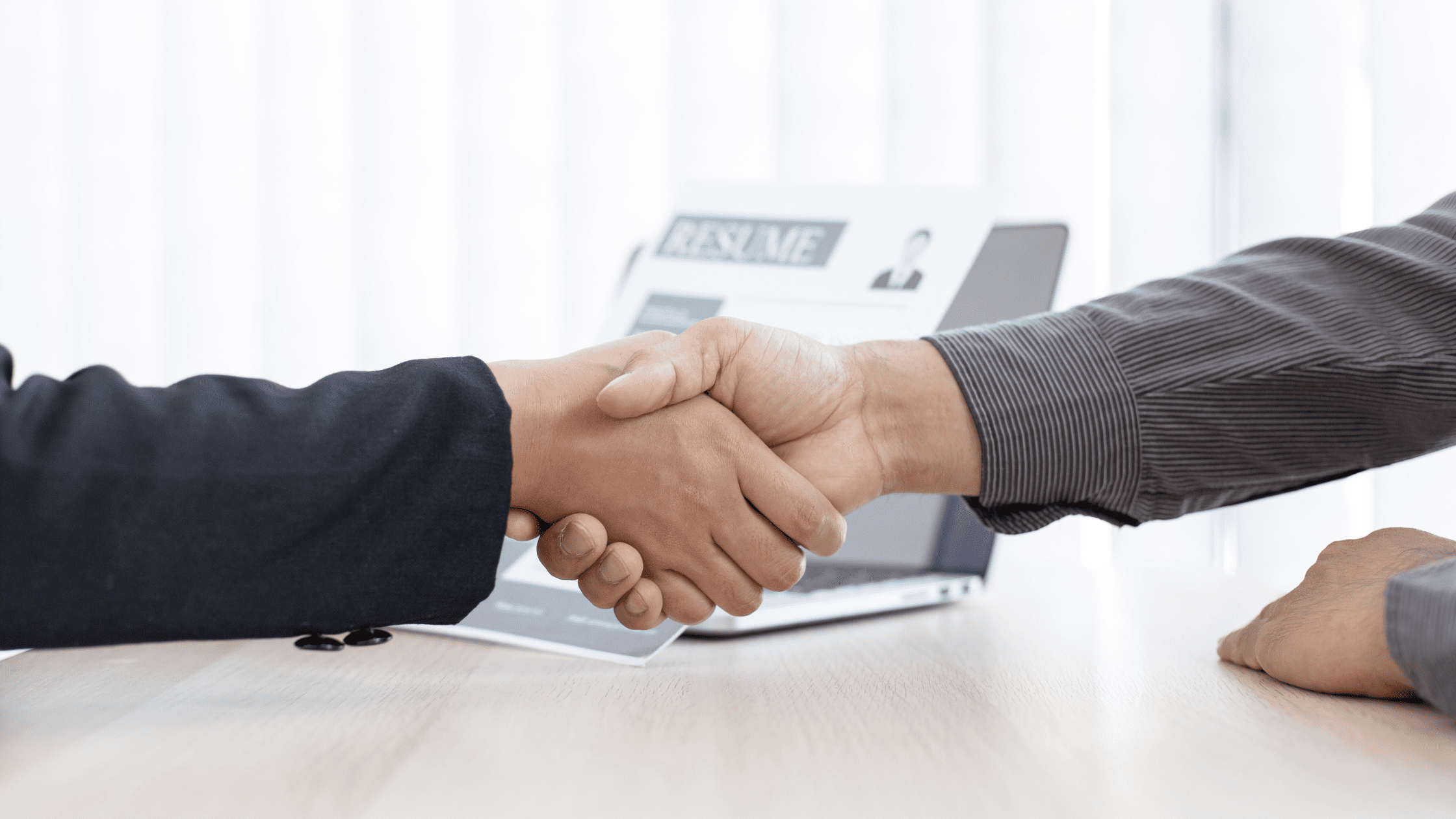 Two people shaking hands at an interview to match into family medicine for residency