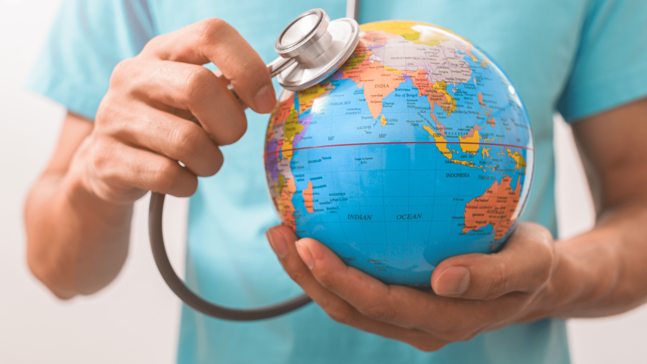 An IMG resident holding a stethoscope against a globe.
