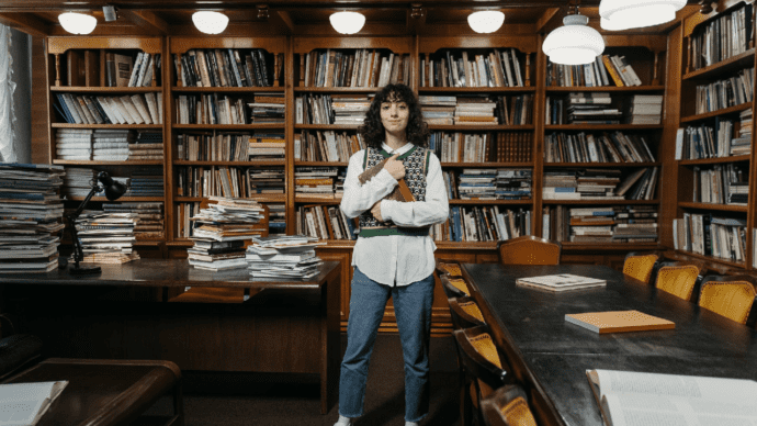 Young woman standing in front of book shelves