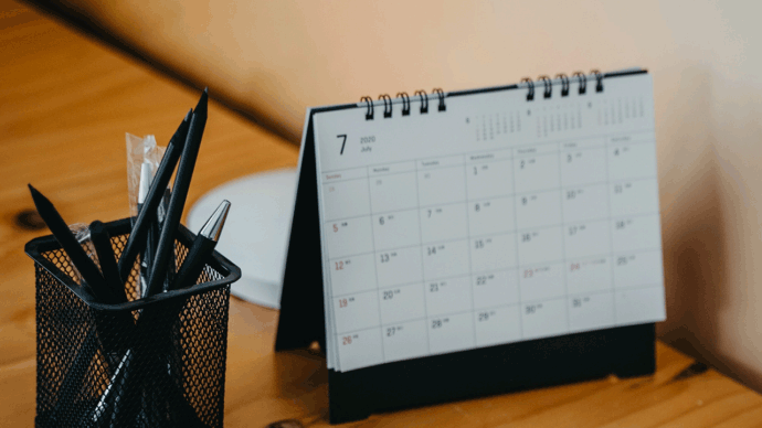 Calendar sitting on desk next to pen cup