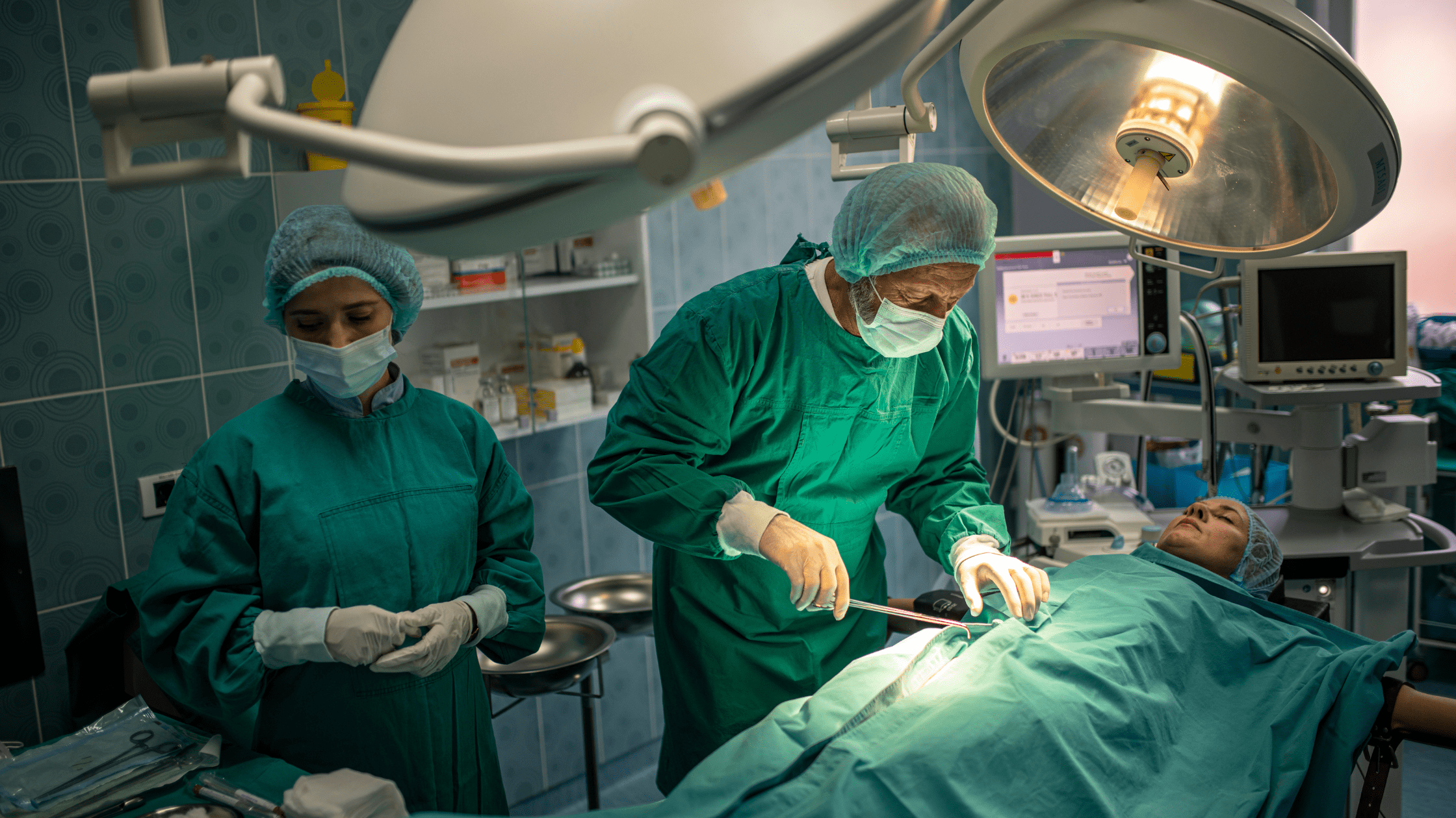 Doctors performing surgery on a patient in an operating room.