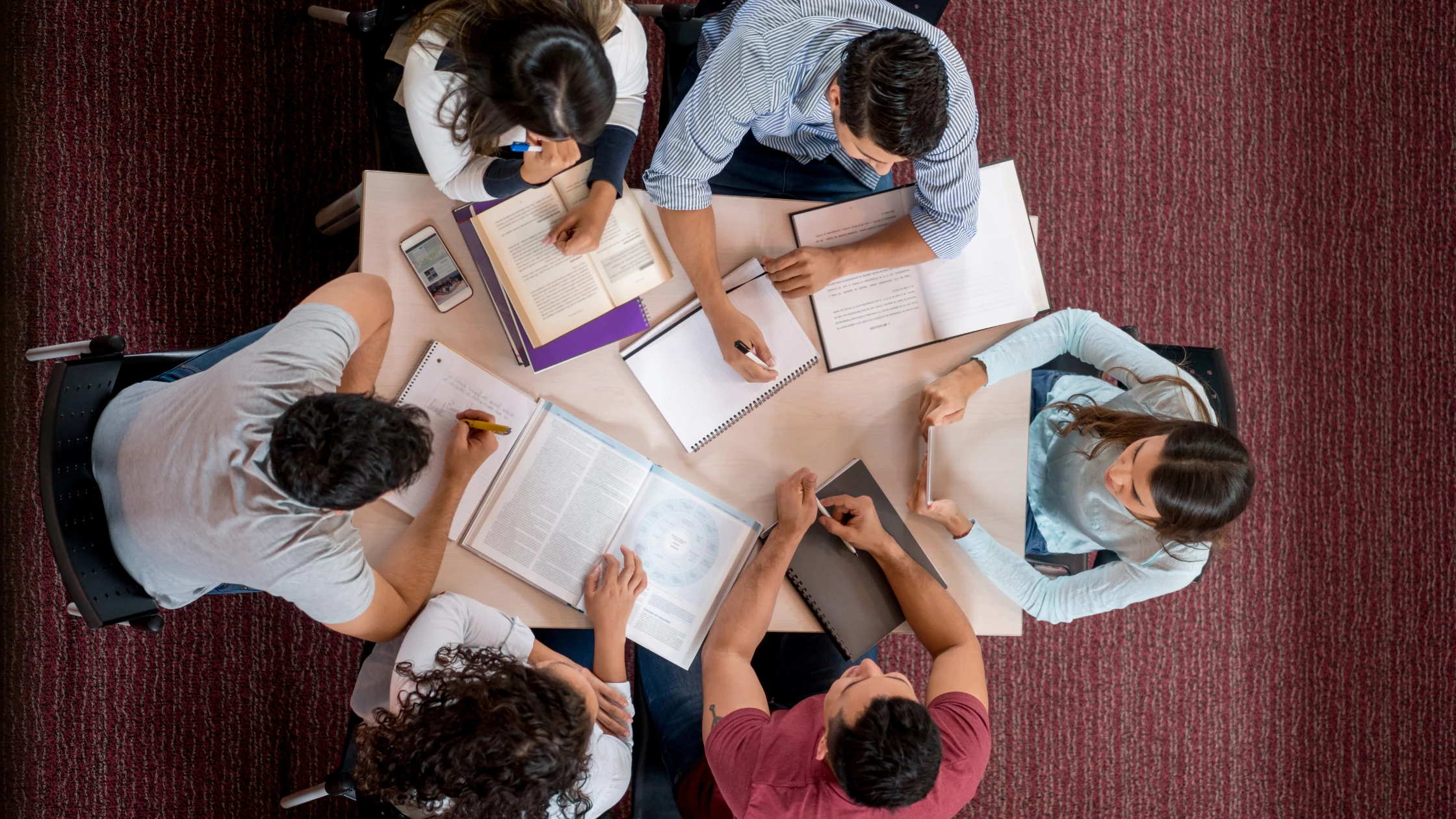 A group of medical school students studying for the surgery shelf exam in a library.